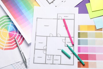 Designer's workplace with house plans, color palettes and stationery on table, top view