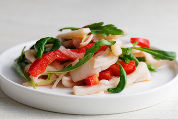 salad with squid, sweet bell pepper and arugula, with dressing, restaurant, no people, Healthy seafood eating concept, close up
