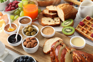 Different meals served for breakfast on white table, closeup. Buffet menu