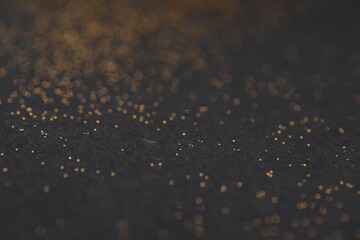 Beautiful shiny golden glitter on black background, closeup