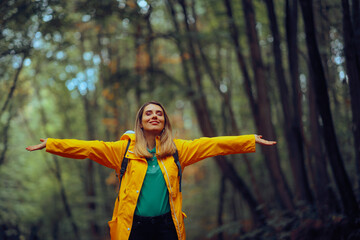 Happy Woman Enjoying the Forest During Spring Season. Carefree tourist relaxing outdoors feeling happiness and nature connection 
