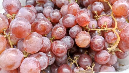Close up on piles of fresh ripe purple grapes sale at farmers market.. View from above.