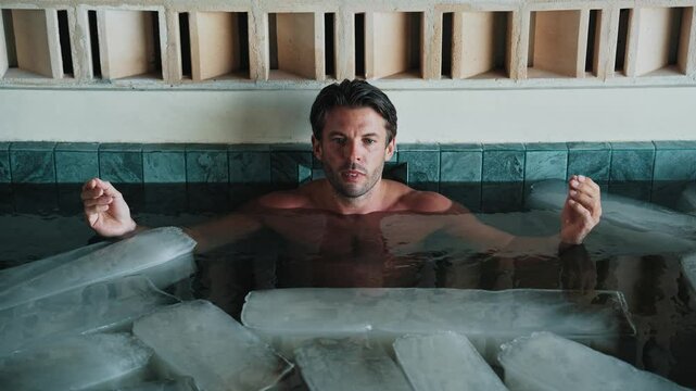 Healthy Man Dives into Cold Water of Swimming Pool with Ice Cubes for Good Body Health. One Beautiful Person in Icy Bathtub Full of Chilly Aqua. Active Remedy for Curing Depression and Healing Anxiety