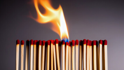A lit match next to a group of unlit matches on dark background, concept for new ideas Leadership teamwork
