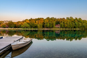 Obraz premium Captivating sunset at Green Lakes Park in Syracuse, NY, showcasing crystal clear waters, lush forests, and serene reflections. Ideal for nature lovers and peaceful getaways.