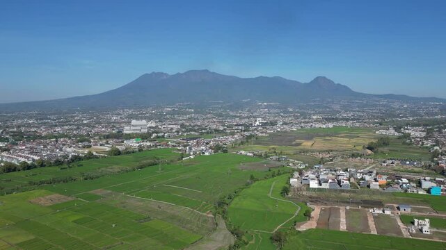 The view from above is a view of residential areas still surrounded by rice fields with a backdrop of Mount Kawi which is located in Batu City in landscape format