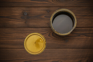 Open Can of Dark Wood Stain on Brown Wooden Surface for Home Improvement Projects
