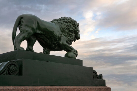 View of the copper lion statue on the Palace Pier on the Admiralteyskaya embankment of the Neva River near the Admiralty building, St. Petersburg, Russia