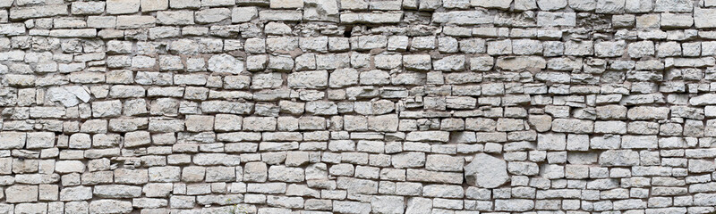 stone wall made of old cobblestones, gray brickwork background