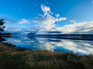 Beautiful views of mountains and blue sky with clouds reflect in the Lake water 