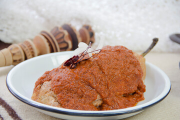 Mexican food Chile capeado with spicy adobo sauce, stuffed poblano pepper and red sauce.