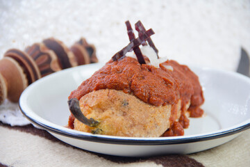 Mexican food Chile capeado with spicy adobo sauce, stuffed poblano pepper and hot sauce, close-up.