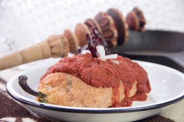 Stuffed poblano pepper chile capeado served with smoky chipotle adobo sauce, plated in authentic Mexican style.