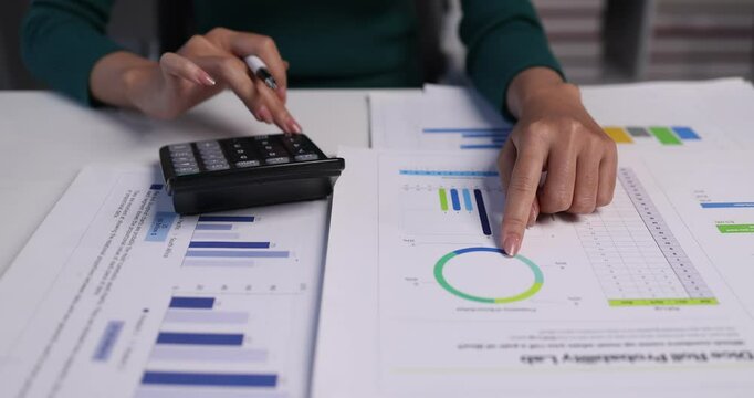 Business financing accounting banking concept. Business woman hand doing finances and calculate on desk about cost at home office. Woman working on desk with using calculator, finance accounting.
