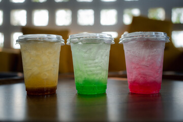 Colorful Italian soda in a plastic cup on the table in summer