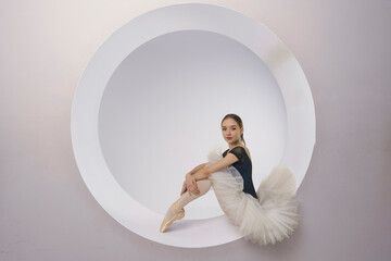 young ballerina in a white tutu sits in a ring set. beautiful ballerina © Alex