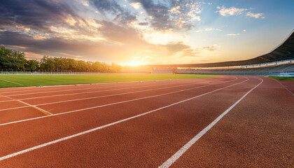 empty running track with sunset on background