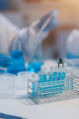 Group of dedicated scientist conduct chemical experiment in medical laboratory, carefully drop precise amount of liquid from pipette into test tube for vaccine drug or antibiotic development. Neoteric