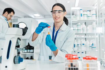 Woman, vial and microscope in laboratory for science, problem solving and solution at table. Scientist, testing or PPE in research facility for medicine engineering, healthcare or forensic innovation