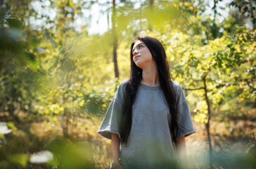 A young girl who breathes fresh air and relieves stress in the forest.