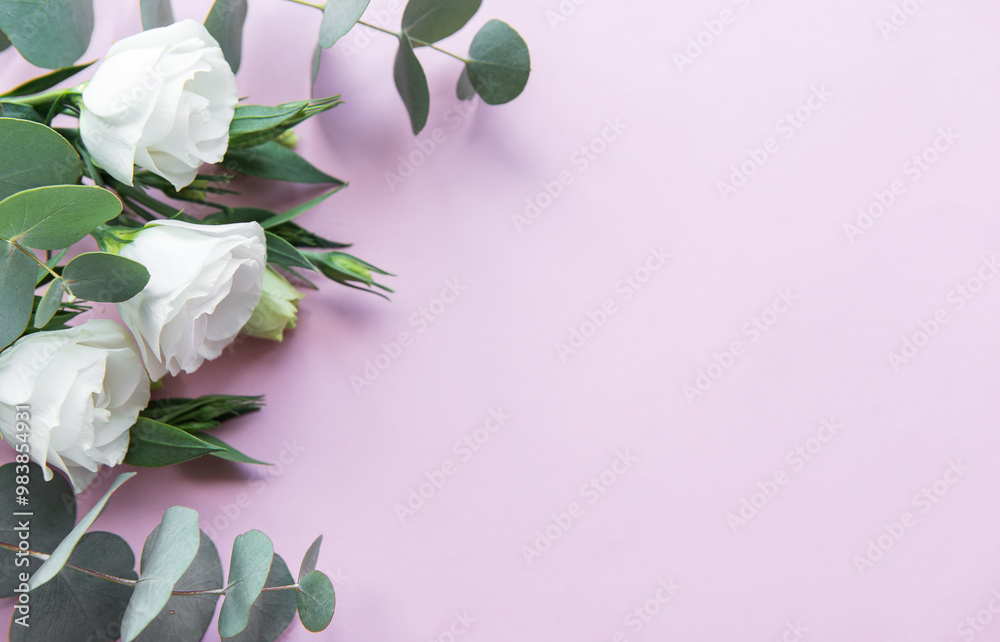 Wall mural soft white roses and eucalyptus leaves arranged on a light pink background, perfect for a wedding or