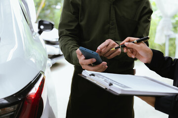 Car rental dealer is signing a rental contract with a professional salesperson. The agent will explain the details about car insurance and maintenance to ensure a smooth rental and service process.