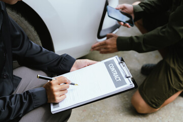 Car rental dealer is signing a rental contract with a professional salesperson. The agent will explain the details about car insurance and maintenance to ensure a smooth rental and service process.