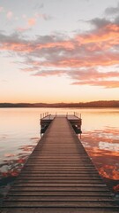 Fototapeta premium Wooden pier extending into calm water at sunset with colorful clouds reflecting on the lake. Tranquil landscape and nature concept. Design for posters, banners, and wallpapers