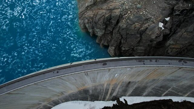 4k Drone Aerial Birds Eye View Of Lac de Moiry Dam With Road On Top And Light Blue Glacial Water In Grimentz Switzerland