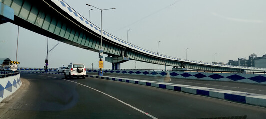 Naklejka premium An urban view of an car plying over and under an overhead bridge