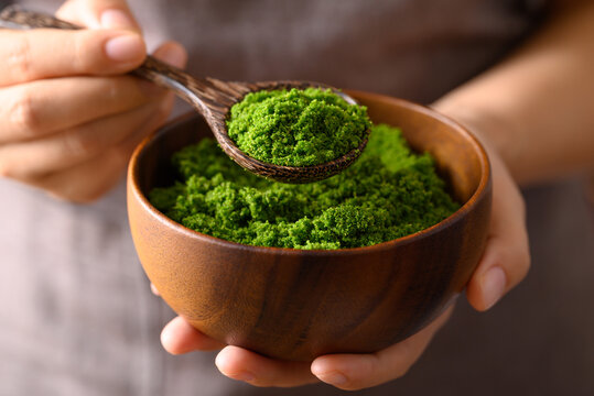 Wolffia or watermeal in wooden bowl with spoon holding by hand, Edible small aquatic plant high protein