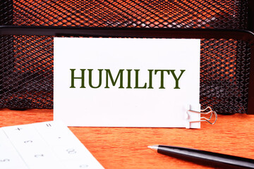 Lifestyle concept. HUMILITY word on a white business card close-up