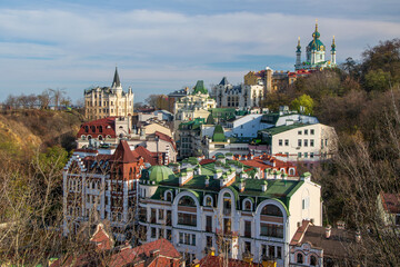 Colorful cityscape of Andriivsky Descent in Kyiv, featuring diverse architecture and crowned by the...