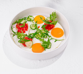 Tasty fried eggs with vegetables and herbs for breakfast