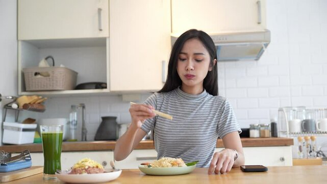 Asian woman eating Thai food and green vegetable juice for healthy