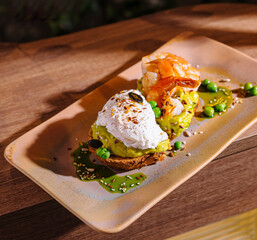 Two slices of avocado toast being served on a plate