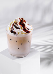 Iced coffee with whipped cream and chocolate sauce on white background