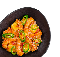 Spicy shrimps and pineapple with white rice and chili pepper slices in black bowl