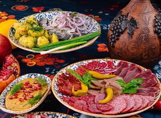Table is set with plates of meat, fish, and sauce