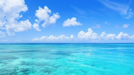 A beautiful scene of the blue ocean against the blue sky background. The ocean stretches out as far as the eye can see, with its surface glistening in the sunlight