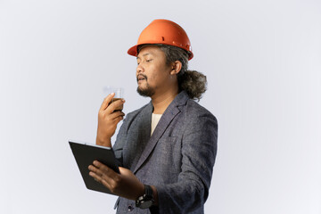 Curly haired male construction worker working using tablet while drinking a cup of coffee, construction and industry work concept, isolated on white background.