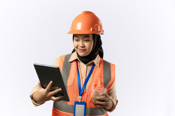 Young Asian female construction worker in hijab carrying tablet, industrial and construction concept, isolated on white background.