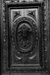 This is a striking black and white photograph that captures a detailed carving of a childs face, highlighting the artistry involved