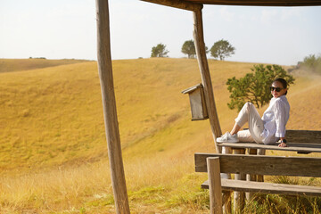 A charming girl enjoys the wind, smile and freedom, sunset and autumn light. Beautiful lady having fun in nature.