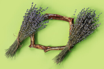 Wooden frames with  bouquet of fragrant lavender in  rustic style on green wall. Holiday party decoration.