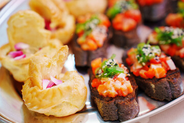 profiteroles and a baguette with vegetables on the banquet table. canapes for a buffet. catering services.