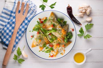 Baked brick pastry triangles filled with eggplant. Top view table with  decoration.