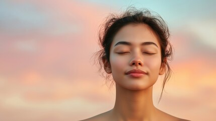 Fototapeta premium A woman with a relaxed expression on her face. She is looking at the camera. The background is a beautiful pink and purple sky