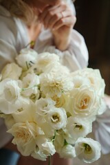 A delicate white bouquet in the hands of the bride. An addition to the wedding look. Floral compositions for the holiday.