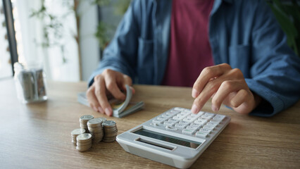 Man calculates finances by calculator Count banknotes and coinsใ